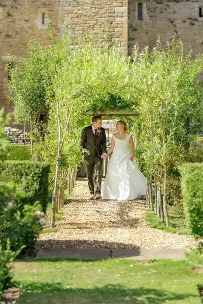 wedding-couple-walking-through-arch
