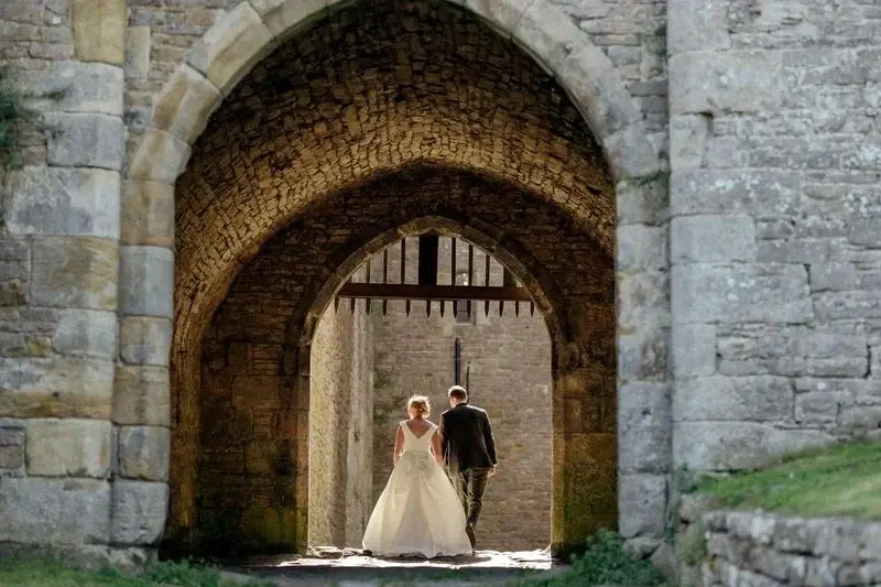 wedding-couple-walking-through-castle-portcullis